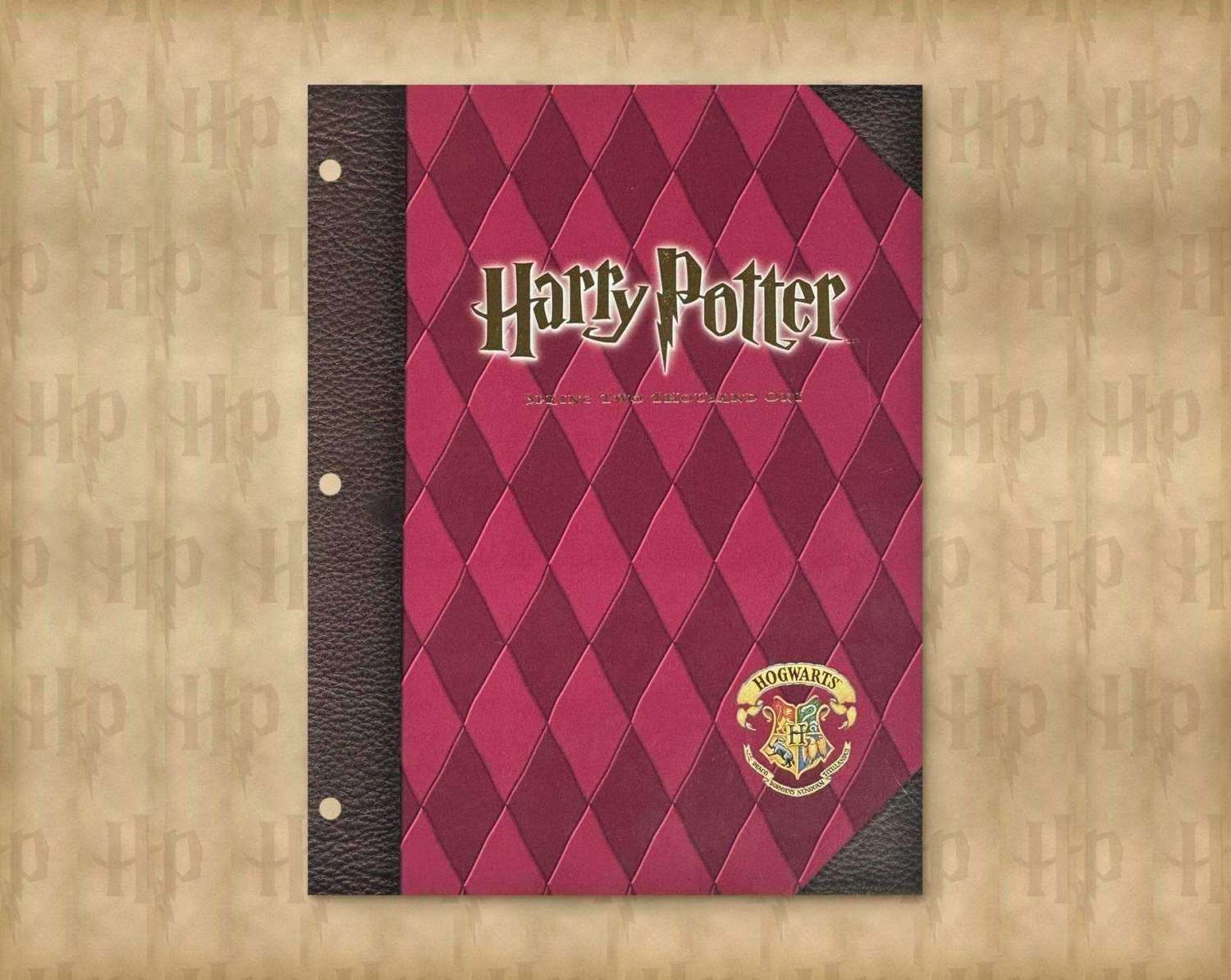 Harry Potter Spring 2001 catalog cover: maroon and pink diamond pattern on a parchment background with a Harry Potter monogram pattern with a brown leather spine and the Hogwarts crest
