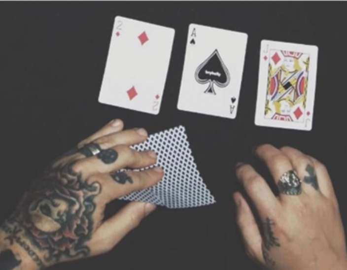 Tattooed hands dealing playing cards